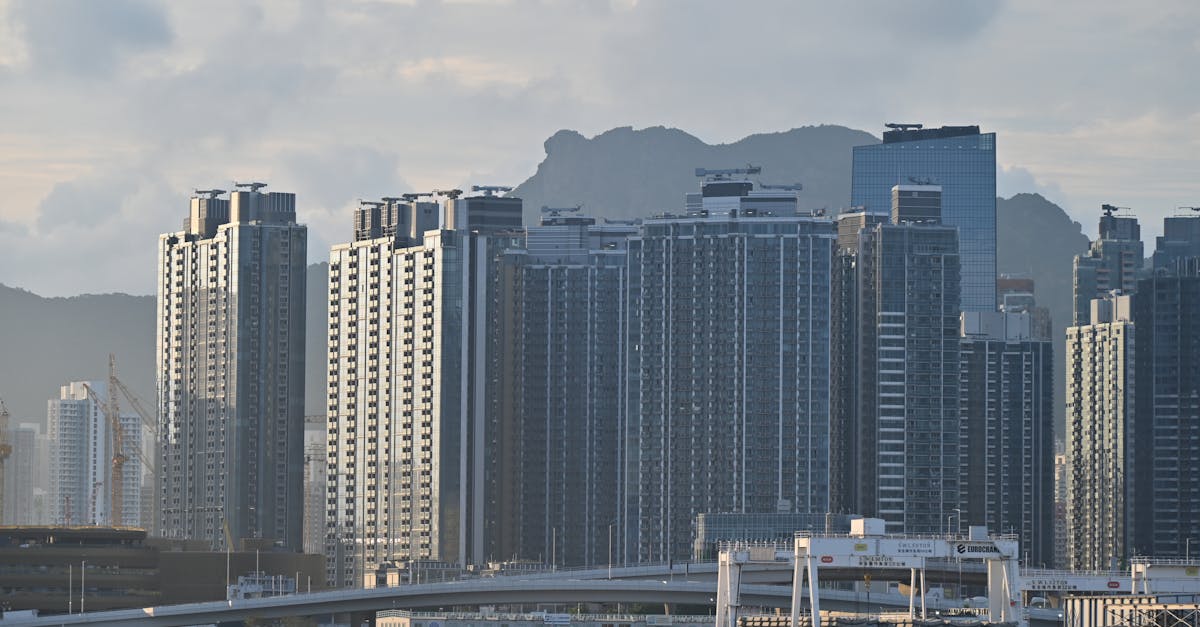 Cityscape featuring towering high-rise buildings against a mountainous backdrop.