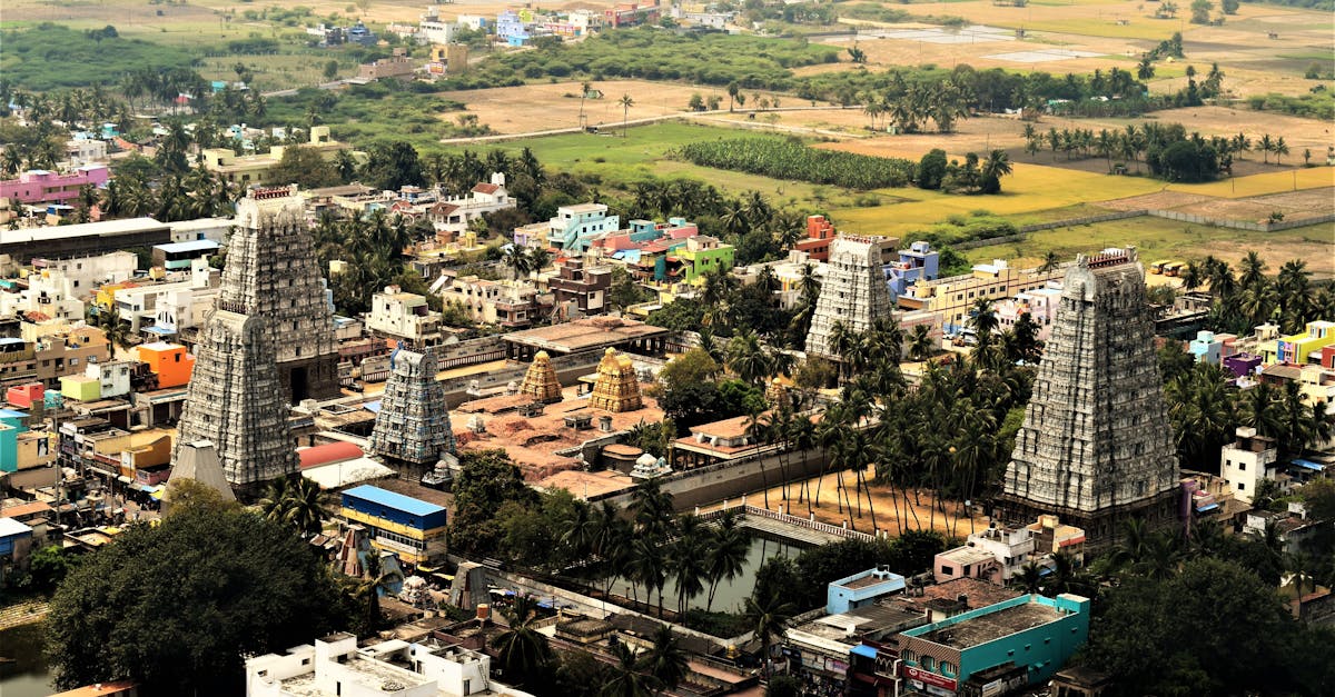 Aerial view of a historic temple complex surrounded by lush fields and colorful buildings.