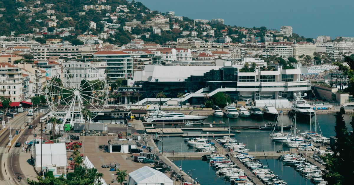 Scenic aerial shot of Cannes harbor with yachts and cityscape, capturing the essence of the French Riviera.