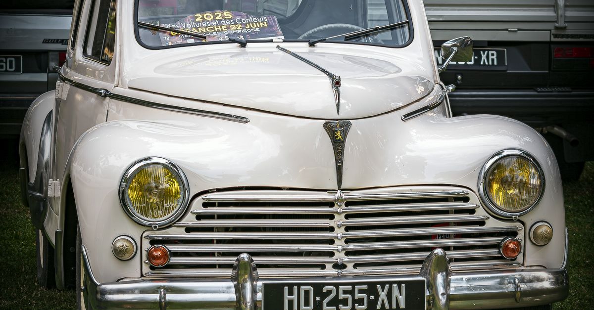 Front view of a vintage Peugeot 203 on display at a car show, capturing its classic design and charm.