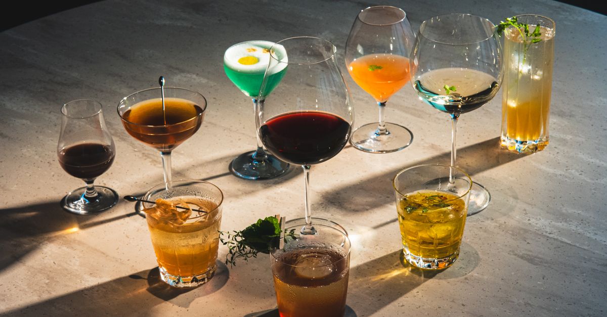 Variety of colorful cocktails and drinks on a bar counter showcasing artistic presentation.