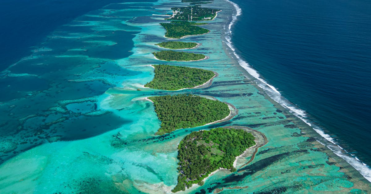 A breathtaking aerial shot of a Maldives atoll with vibrant blue waters and green islands.