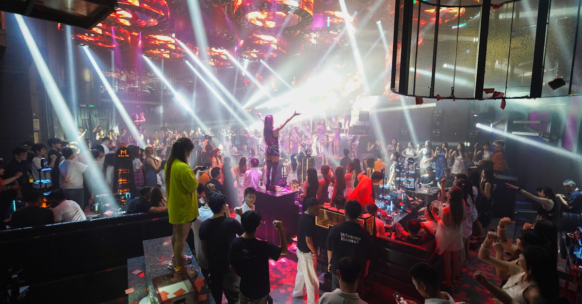 Crowded nightclub with vibrant lighting and people dancing, capturing nightlife energy.