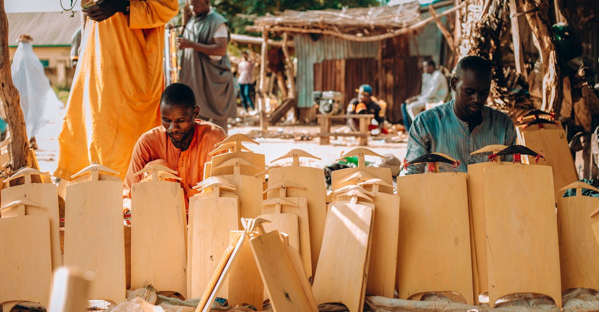 Artisans at work crafting wooden items in an outdoor market setting, showcasing traditional craftsmanship.