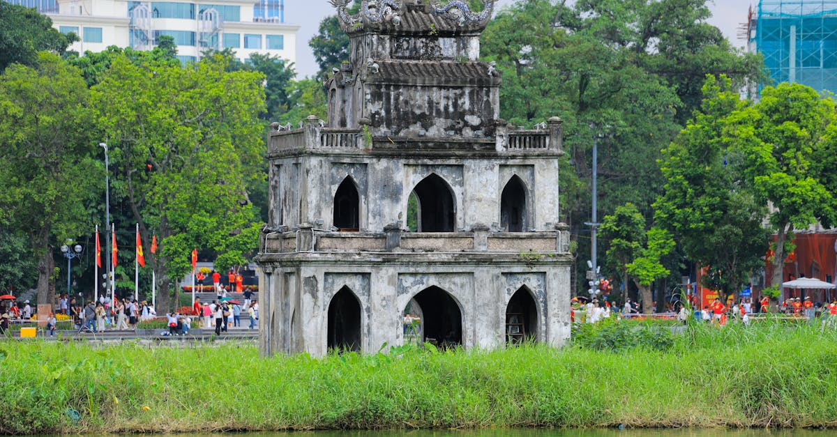 Historic Turtle Tower in Hoan Kiem Lake surrounded by lush greenery in Hanoi, Vietnam.