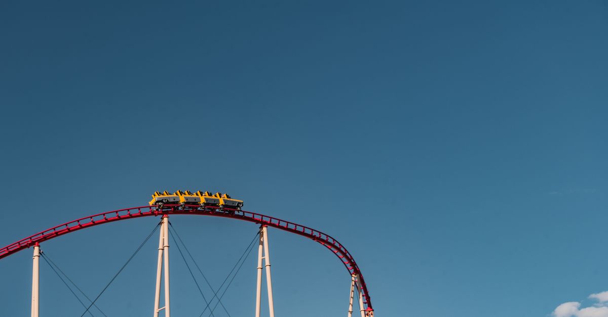 Captivating view of a roller coaster under clear blue sky, capturing adventure and thrill.