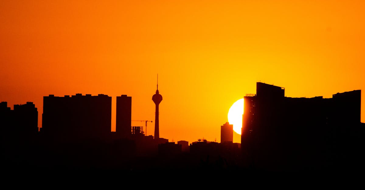 Silhouette of city skyline against a vibrant sunset sky.