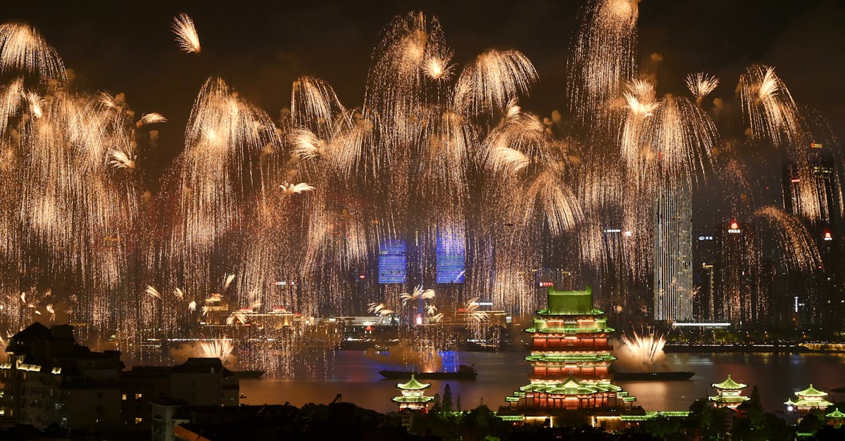 Dazzling fireworks illuminate a majestic pagoda and city skyline at night, creating a breathtaking spectacle.