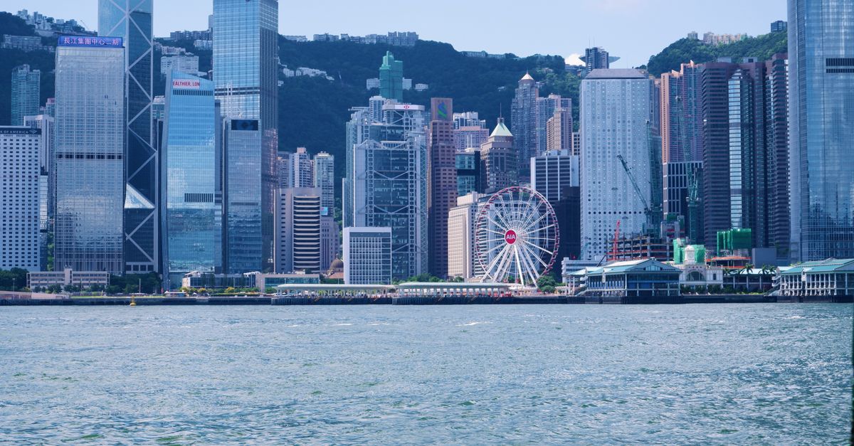 Stunning view of Hong Kong skyline with skyscrapers and observation wheel from Victoria Harbour.