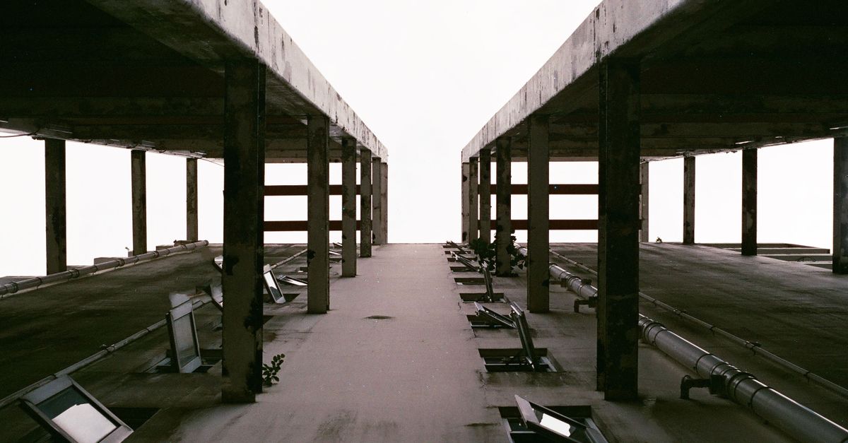Abstract view of an industrial structure with symmetrical lines and muted tones, showcasing urban architecture.