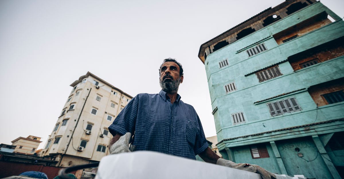 Portrait of a man in Damietta, Egypt with urban buildings in the background.