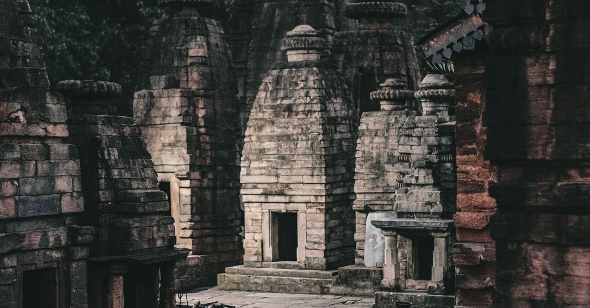 Ancient stone temples with intricate architecture in a moody, mystical setting.
