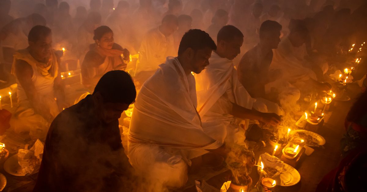 People gathered in a dim, smoky room for a spiritual candlelit ceremony, evoking a serene and contemplative mood.
