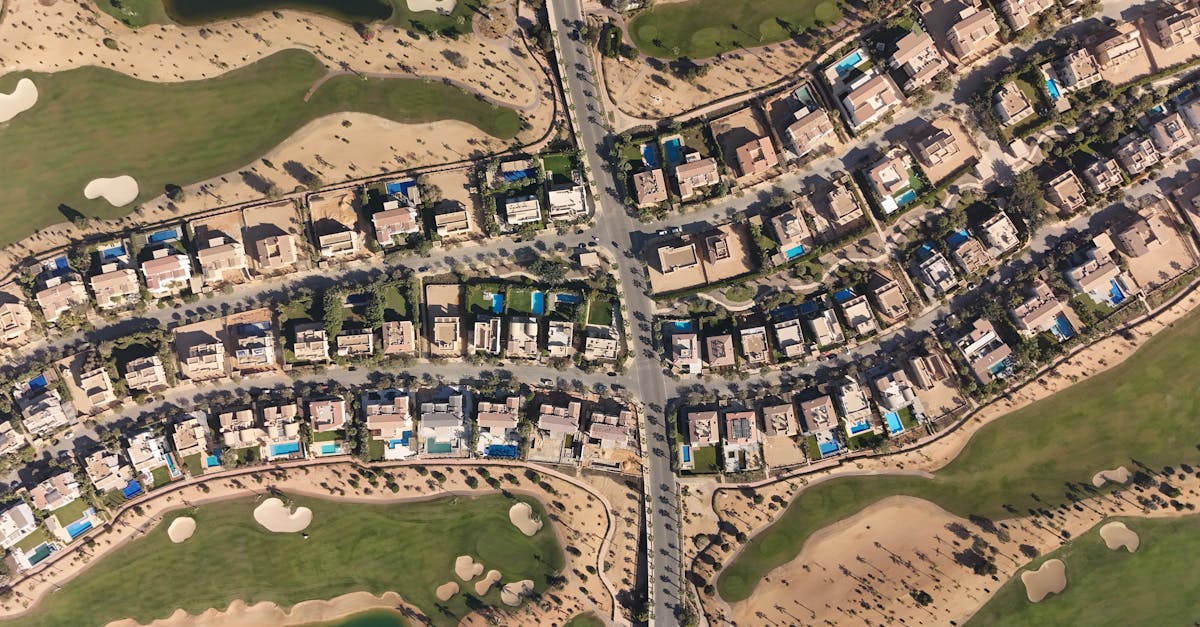 Aerial shot of luxury villas and golf course in Sheikh Zayed, Cairo, showcasing modern architecture and lush greenery.
