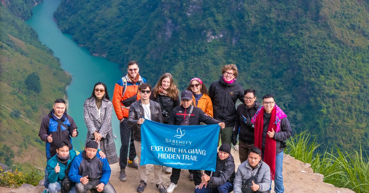 Explore Ha Giang's hidden trails with a diverse group enjoying breathtaking mountain views.
