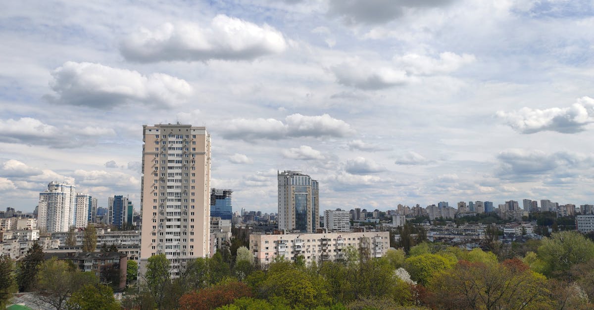 High-angle view of cityscape with clouds and lush greenery in spring.