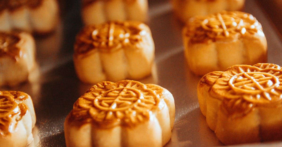 Close-up view of traditional mooncakes freshly baked on a tray, showcasing detailed patterns.
