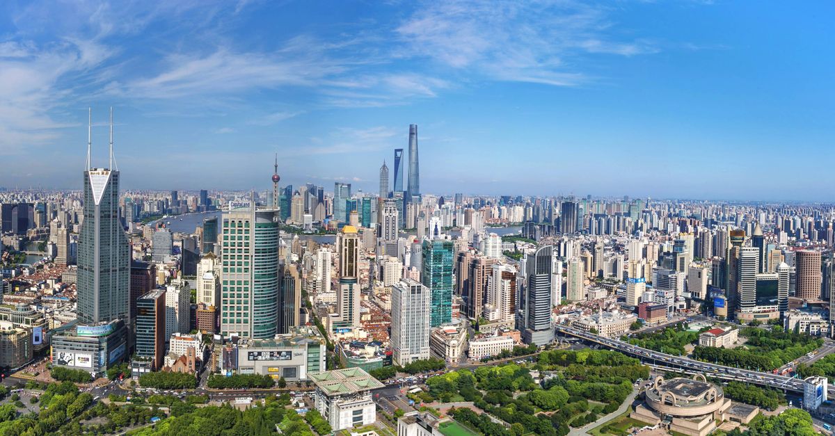 A stunning aerial view of Shanghai's modern skyline with iconic skyscrapers under a clear blue sky.