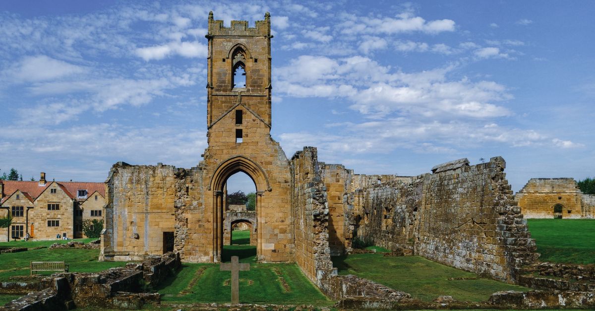 Explore the medieval ruins of Mount Grace Priory under a clear sky in England.