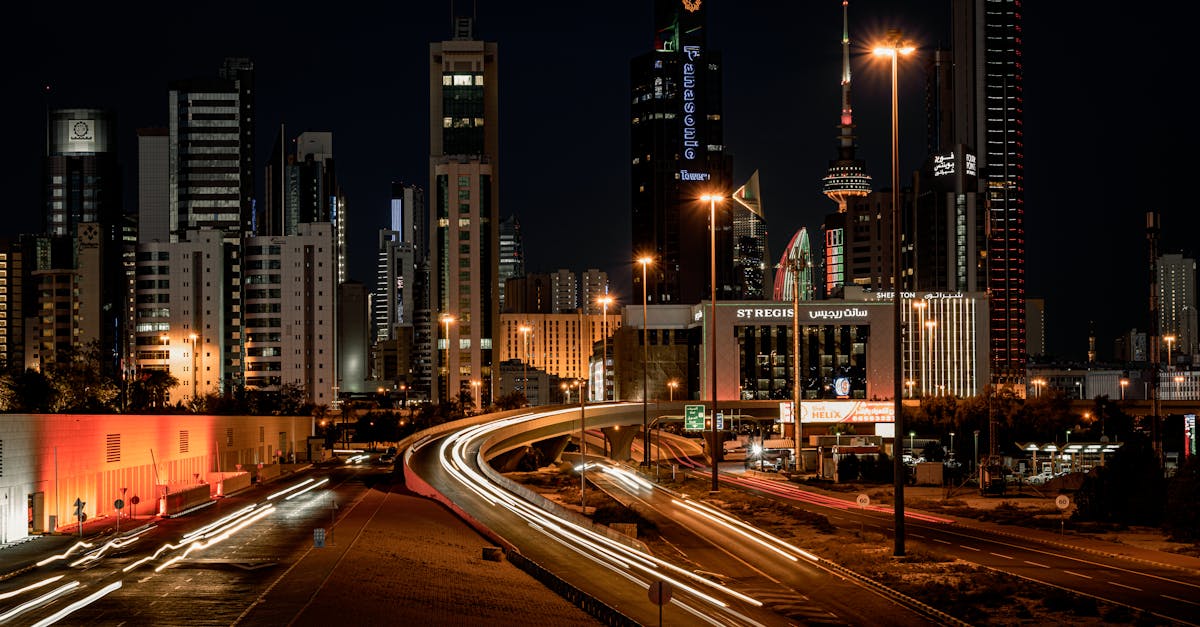 Nighttime cityscape showcasing Kuwait City's illuminated skyline and bustling streets.