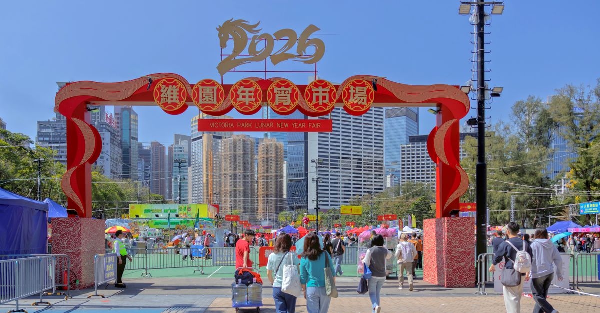 Crowds enjoying the vibrant 2026 Lunar New Year Fair at Victoria Park, Hong Kong under clear blue skies.