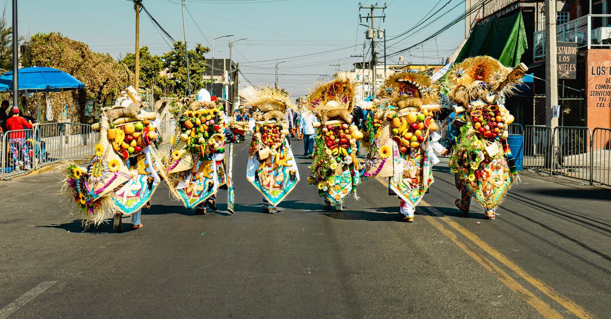 Vibrant traditional parade with costumed participants in Huejotzingo, Mexico.