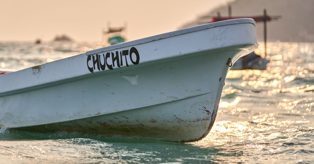 A detailed view of a boat named Chuchito in bright sunlight on the ocean.