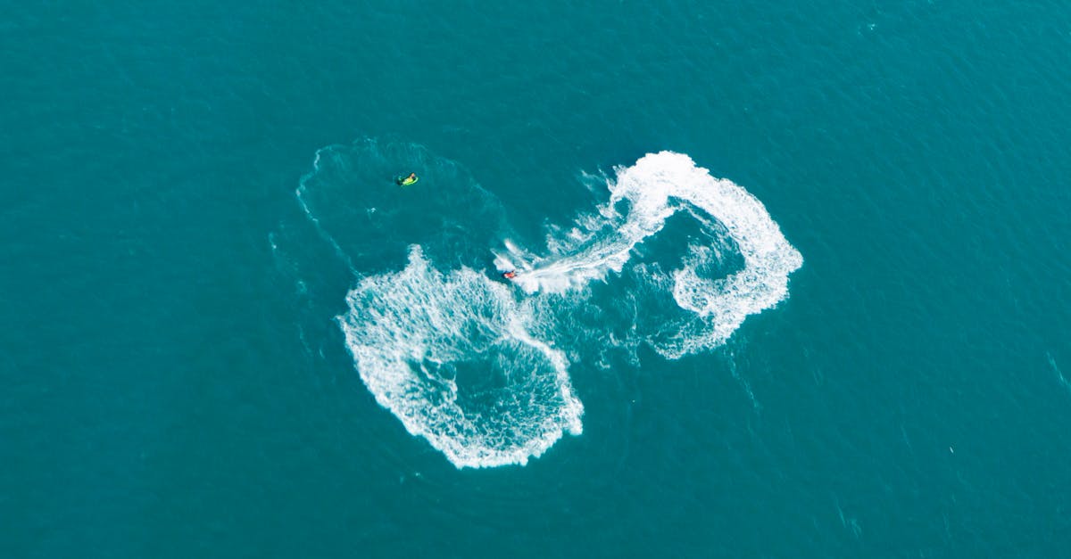 Top view of a jet ski making intricate water trails on a blue sea, perfect for adventure themes.