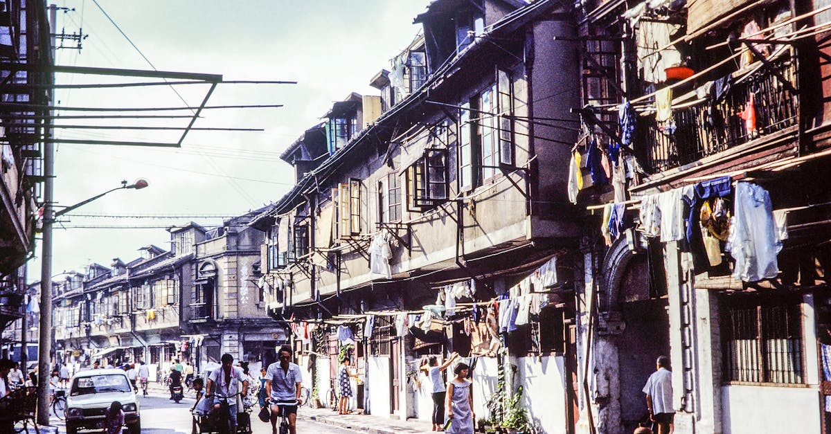 A vibrant street in an old neighborhood with people biking and walking.
