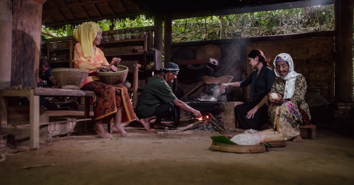 A group of people cooking using traditional methods in Malang, Indonesia, showcasing cultural heritage.