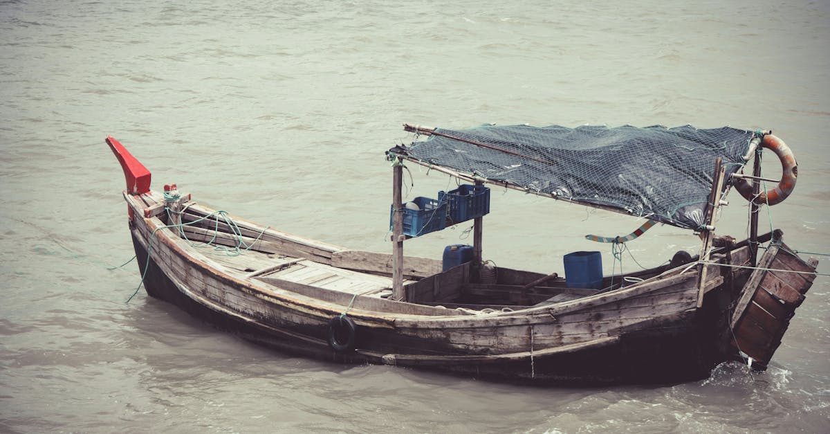 Vintage wooden fishing boat floating on calm waters, exuding a serene coastal vibe.