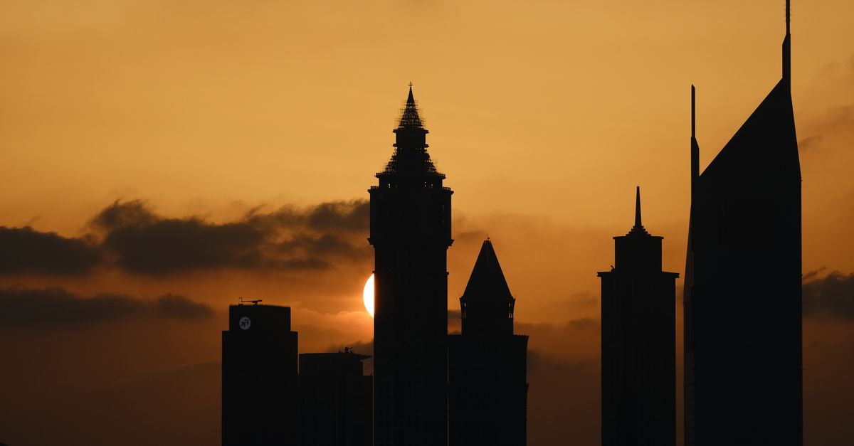 Silhouette of Dubai's iconic skyline against a dramatic sunset.