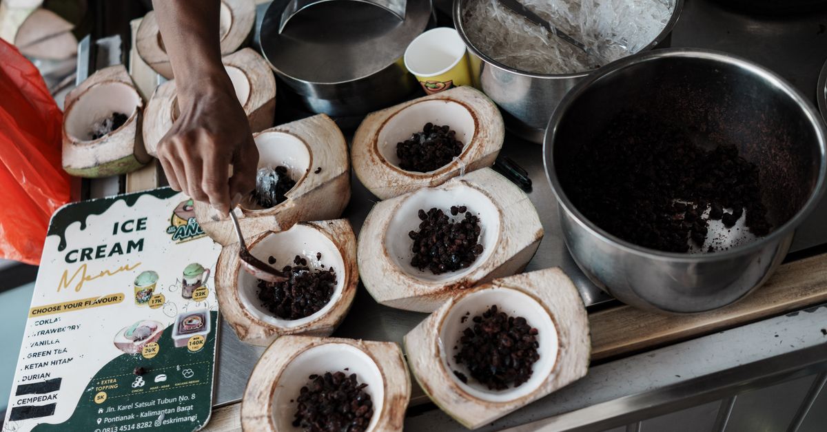 A vendor prepares coconut ice cream in Pontianak, Indonesia, with natural ingredients and traditional methods.