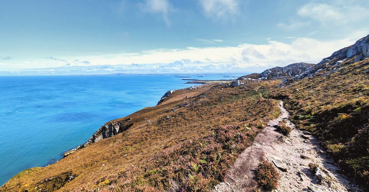 Discover the breathtaking coastal path in Wales with views of the vast ocean and rugged cliffs.