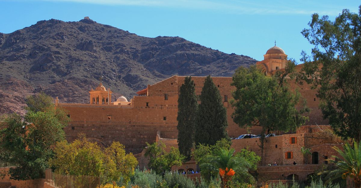 St. Catherine's Monastery, surrounded by Sinai mountains, under clear sky.