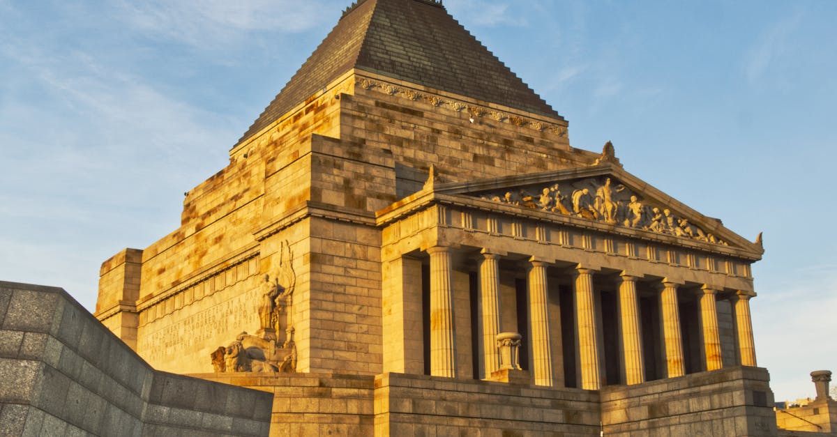 Majestic view of the Shrine of Remembrance during golden hour in Melbourne. Iconic war memorial against a blue sky.
