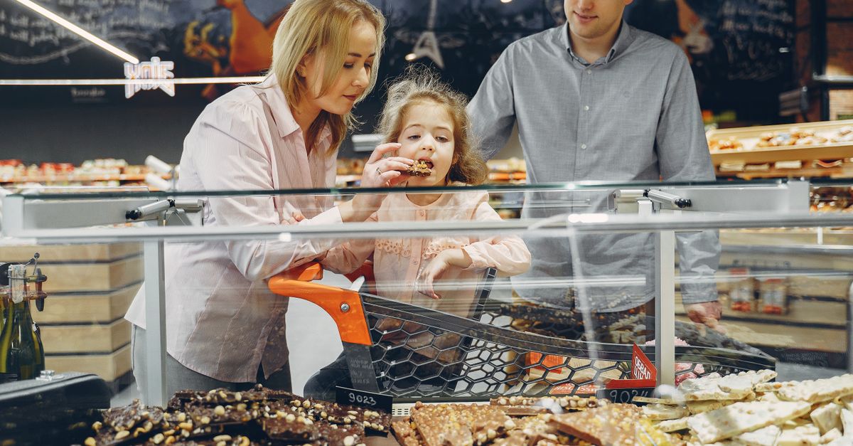 A family samples chocolates in a supermarket, sharing joy and togetherness.