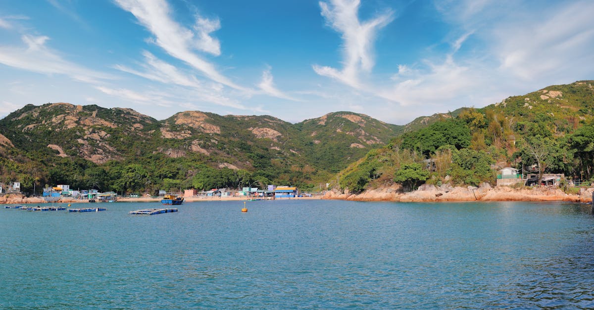 Stunning landscape of Hong Kong's coastal countryside with blue skies and mountains.