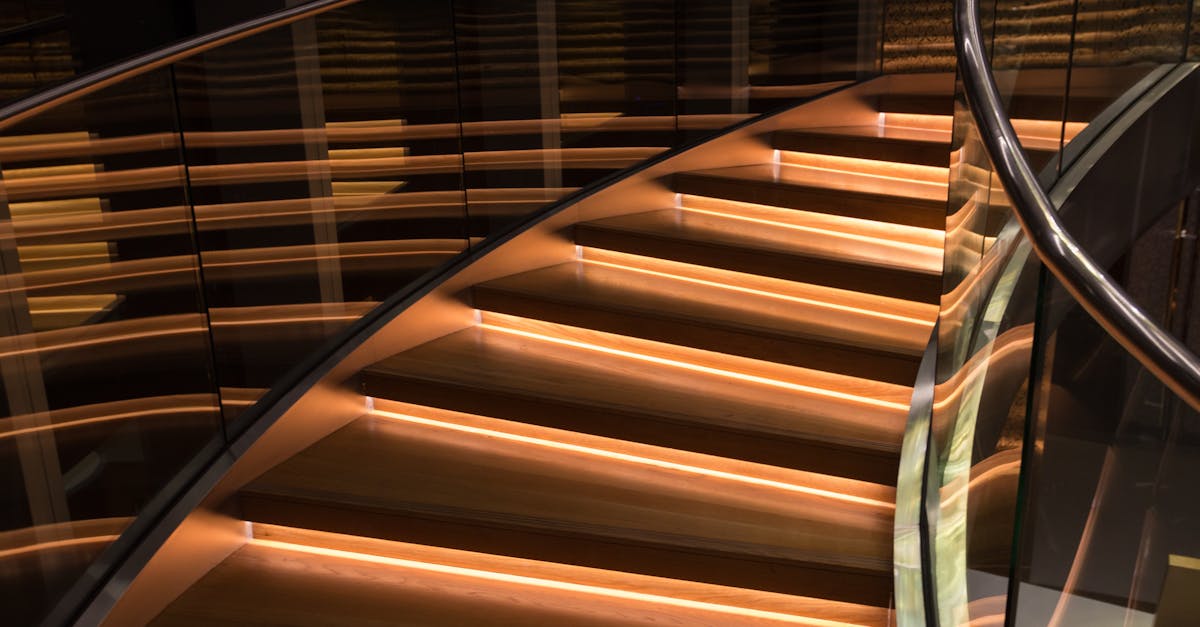Curved staircase with glass and LED lighting creating luxury ambiance.