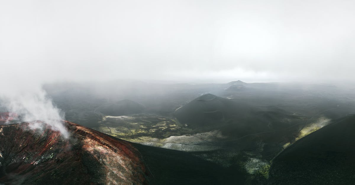 An aerial shot capturing the foggy view of volcanic craters shrouded in mist.