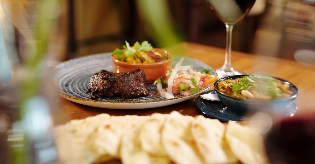 A beautifully plated gourmet meal with red wine, perfect for fine dining enthusiasts.