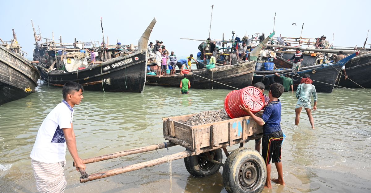 People unloading fishing boats at Chattogram harbor, Bangladesh.