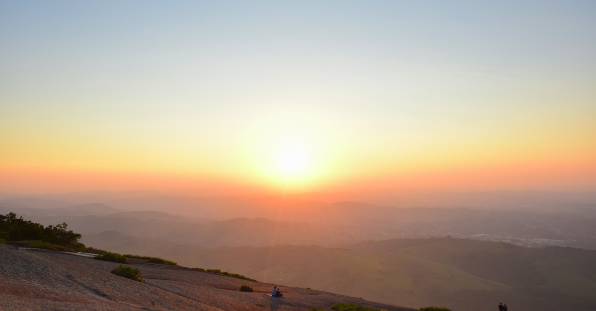 A breathtaking sunrise over a vast mountainous landscape with clear skies.