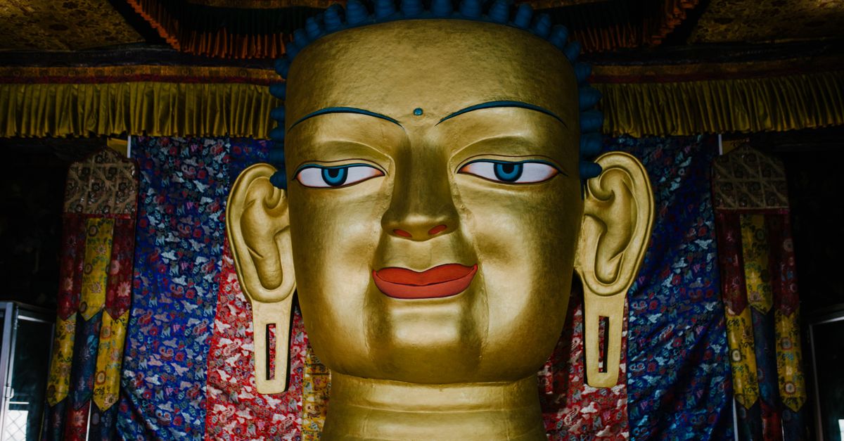 Stunning close-up of a golden Buddha statue surrounded by colorful temple decor.