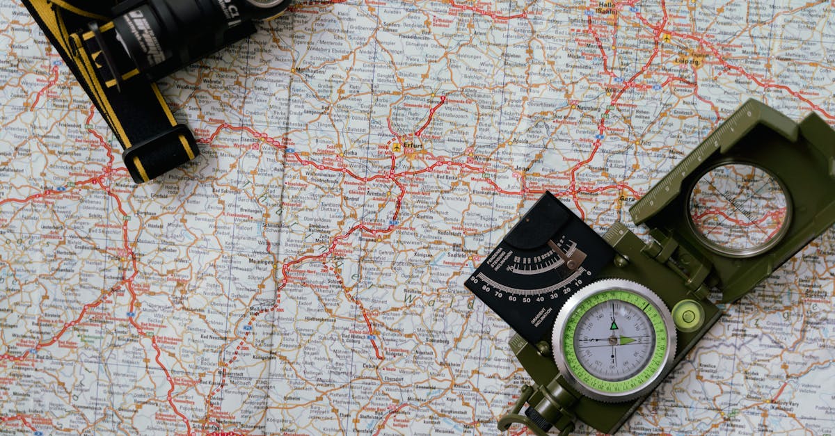 Overhead view of a map with a compass and flashlight showing navigation tools.