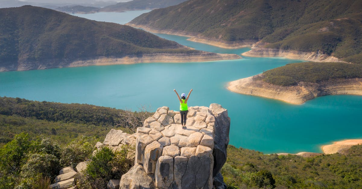 Explore the breathtaking aerial view of a turquoise reservoir in New Territories, Hong Kong, with scenic mountains.