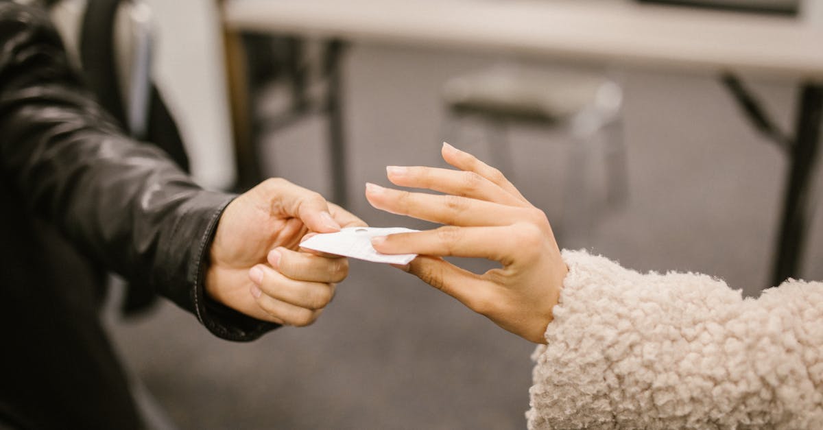 Close-up of two people exchanging a note, hinting at secretive communication.