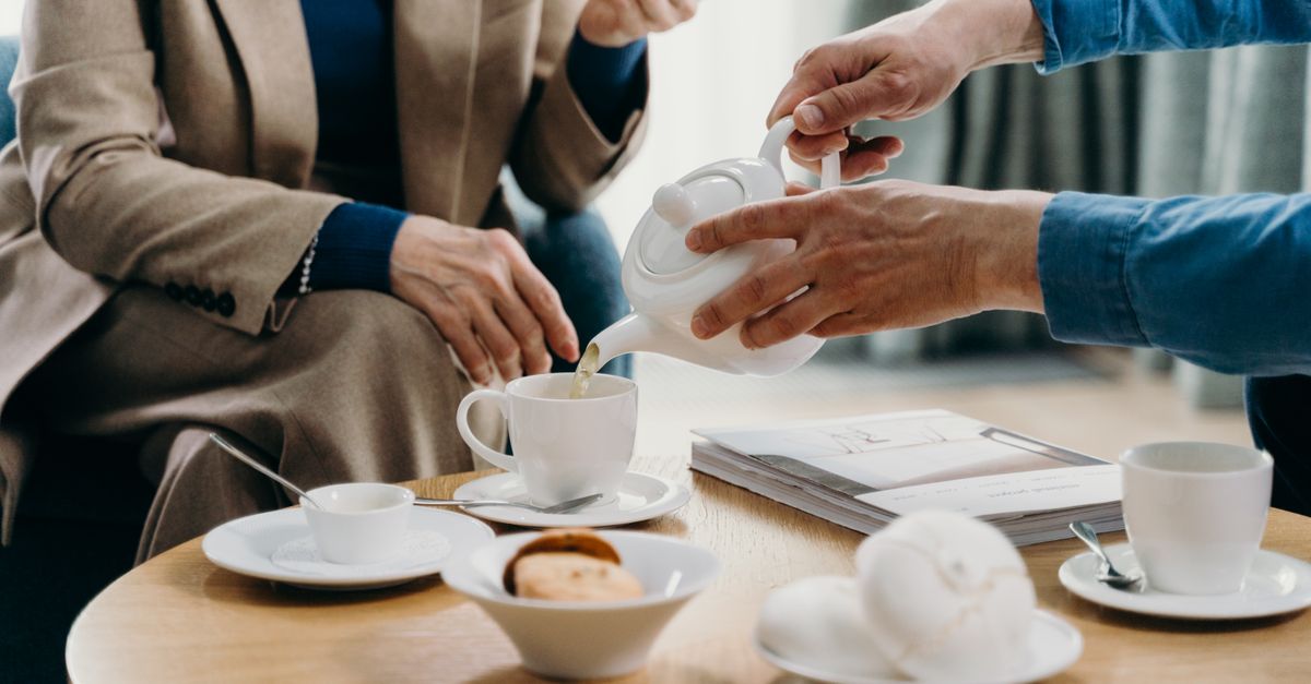 A cozy indoor setting featuring tea and cookies on a wooden table, perfect for connection.