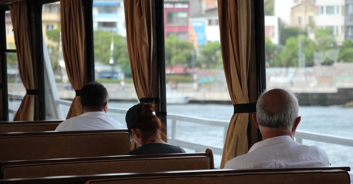 Passengers seated on a ferry in İstanbul, Türkiye, enjoying the view outside.