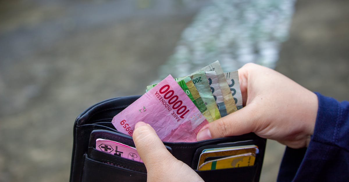 Close-up of hands managing banknotes, focusing on Indonesian Rupiah and diverse currencies